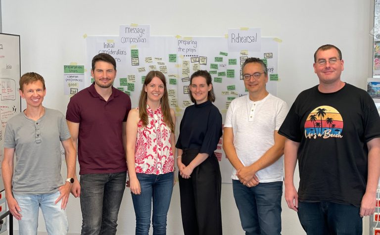DIPF team members (six persons) standing in front of a wall. The wall is partially covered with post-its.